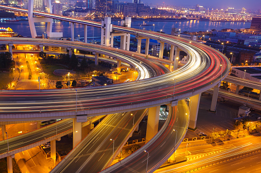 Elevated road interchange at dusk with light trails